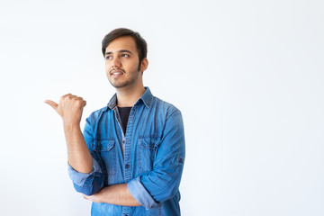 Confident young Indian man pointing at copyspace with thumb