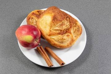 Top view on apple buns with cinnamon on a white plate