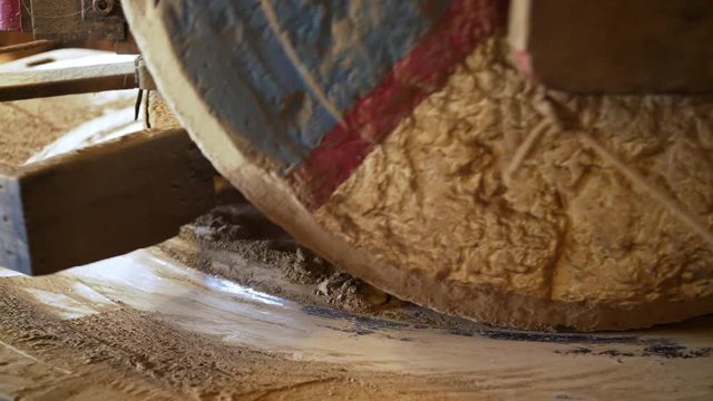 Close-up of grinding mechanism with two millstones which grind wheat into flour inside a traditional windmill in Holland, Zaanse Schans.