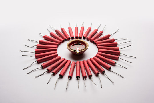 Diwali Firecrackers along with Clay oil lamp or Diya arranged over white background to create a beautiful rangoli or design