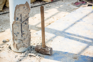 Worker holding hammer and smash to concrete pile in construction site for renovate old house. Renovation and maintenance the property is concept