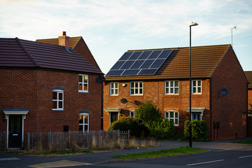 Fototapeta na wymiar Solar photovoltaic panels mounted on a tiled new familiy houses roof, England