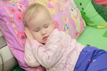 little girl sleeping on pillow with palm under head