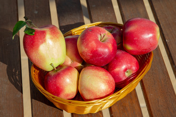 apples in a basket on wooden table