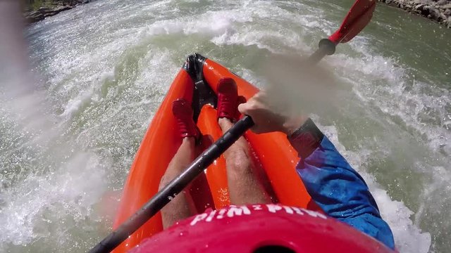 Kayaking down a river with rapids in colorado captured with a camera attached to helmet