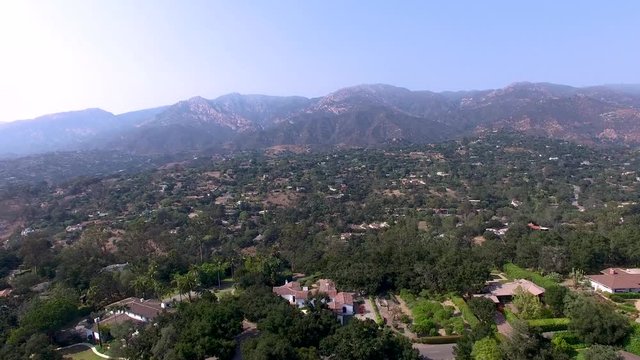 Rising aerial shot in California of mansions at the base of mountains