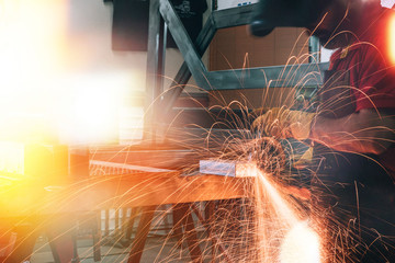 welder is welding metal part in car factory