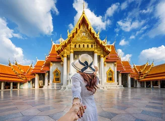 Fotobehang Bangkok Vrouwelijke toeristen die de hand van de man vasthouden en hem naar Wat Benchamabophit of de marmeren tempel in Bangkok, Thailand leiden.