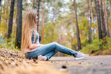 Young woman outdoors in park on sunny autumn day