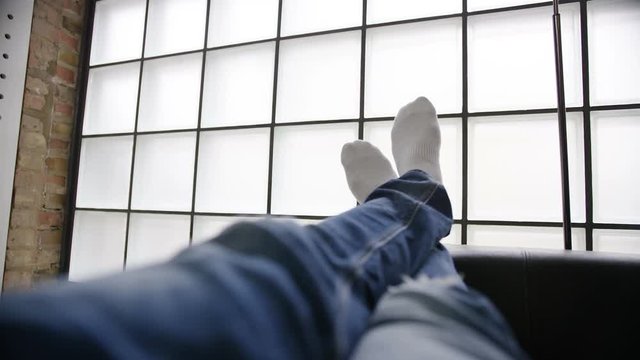 Wide shot of feet relaxing on a couch