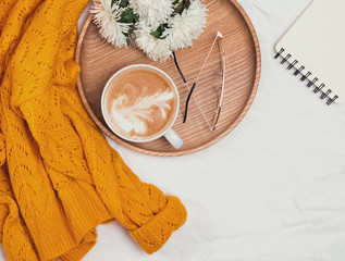 Fototapeta na wymiar Coffee, flowers and yellow sweater on the white background