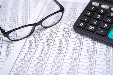 calculator and glasses on financial chart, business concept.