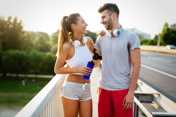 Couple jogging outdoors in the nature and smiling