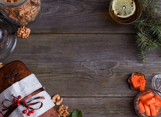 Sweet honey cake with berries and nuts on a wooden table. Pumpkin jam and chocolate under glass.