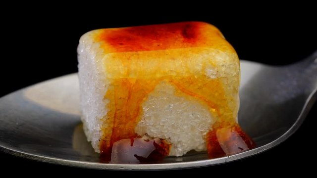 Cube of sugar melts under the influence of high temperature. Close up. Time lapse.
