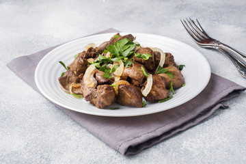 Baked chicken liver with onion on a plate