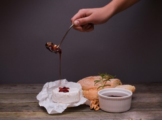 Fresh bread, Camembert cheese and cowberry jam served on a vintage styled dark wooden table. Menu design horizontal