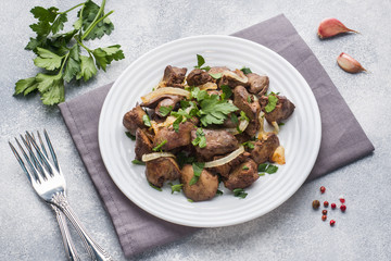 Baked chicken liver with onion on a plate