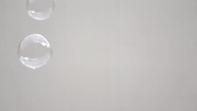 Abstract white background with soap bubbles, pubblic entertainment. Slow motion