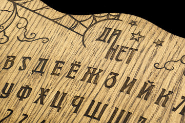 Ouija Board, yellow on a black background