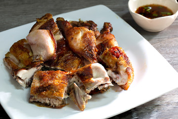 Grilled chicken style Thai ancient and bamboo for grilled, ln white dish with chili sauce in white bowl Thai Food all on wooden background