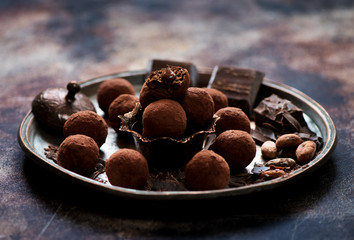 Bliss balls chocolate candies, pieces chocolate and cocoa beans on a metal tray