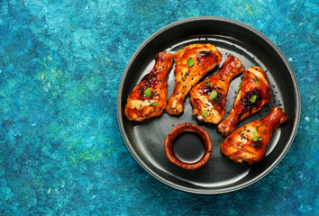 Grilled Spicy chicken legs with soy sauce, on a tray. Top view and space for text