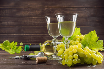 wine glass and bunch of grapes on wooden table