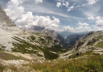 Panorama di vallata e sentiero di montagna con cielo sereno e nuvole alle Tre Cime di Lavaredo