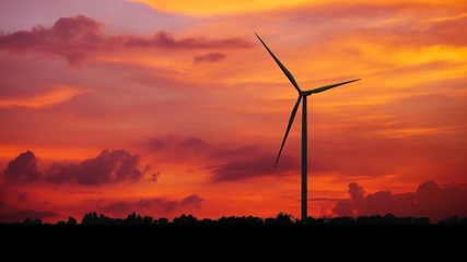 Fototapeta na wymiar Silhouettes Wind turbine power generators at sunset, Alternative renewable energy production, Large wind turbine for electric