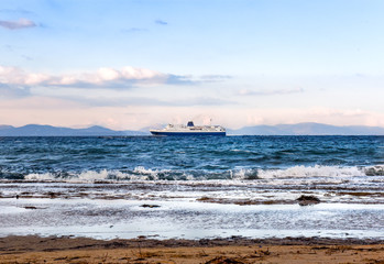 Large blue-white ferry ship leaving port of Rafina on a winter day
