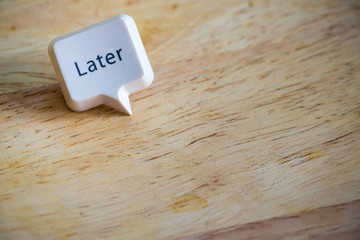 Word “Later” white button on wood texture background in the left corner with space for add...