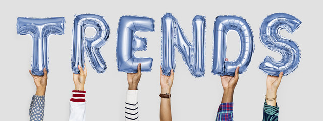 Blue alphabet helium balloons forming the text trends