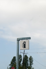 old white gas station sign hanging on a pole