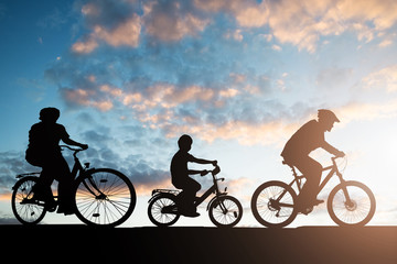 Fototapeta na wymiar Silhouette Of Family Riding Bicycle