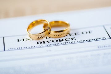 Two broken golden wedding rings divorce decree document - obrazy, fototapety, plakaty