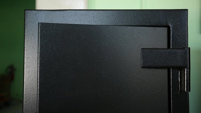 Opening of a door of safe. Opening of an external door of the safe. Behind her it is visible to one more section. The section is protected by one more door. The key is inserted into her. 