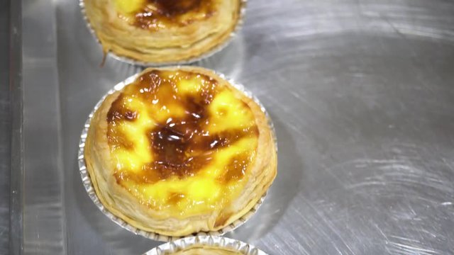 Close-up and follow shot of chef hand making and baking egg tarts as well as putting aluminium foil in kitchen
