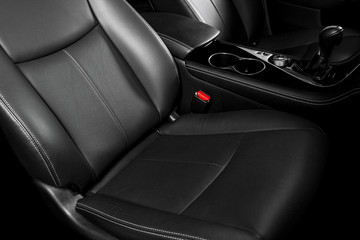 Modern Luxury car inside. Interior of prestige car. Comfortable leather seats. Black perforated leather cockpit with stitching. Steering wheel and dashboard. Automatic gear stick shift. Car detailing