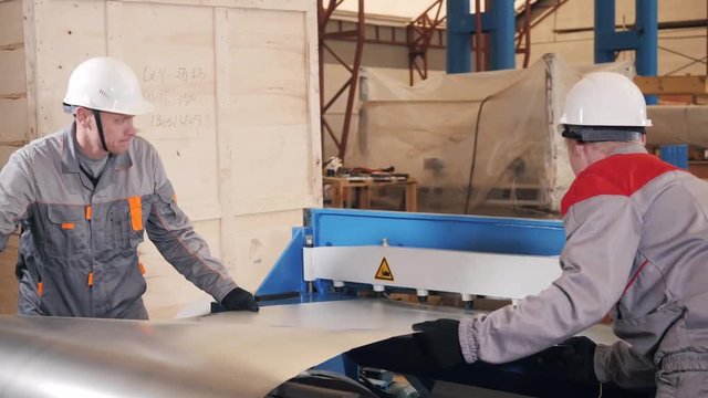 manufacture workshop. Workers adjusts the machine in the warehouse. the production of ventilation and gutters. Tool and bending equipment for sheet metal.