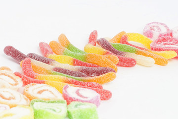 Creative arrangement of colorful candies and sweets on white background