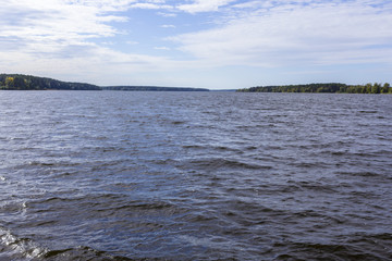 Early autumn. Sunny day. The Volga River near Konakovo. Dense forest on the shore. Tver Region, Central Russia.A background for the site about travel.