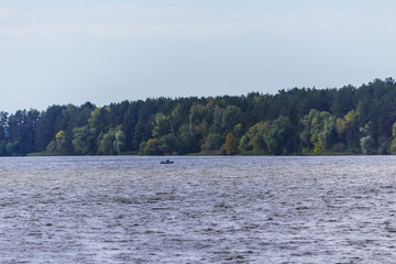 Early autumn.The Volga River near Konakovo.A motor boat with a fisherman.Tver Region, Central Russia.Background for the site about travel and fishing.