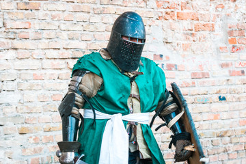 Medieval knight in armor. Green clothes.