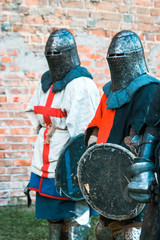Two medieval knights in armor. With a cross.