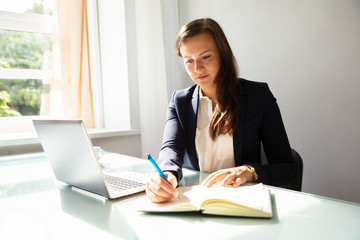Businesswoman Writing Note In Diary
