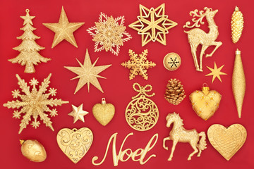 Christmas noel sign and gold bauble decorations on red background. Traditional Christmas greeting card for the holiday season.