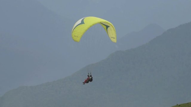 Paragliding with two people over mountains in slow motion