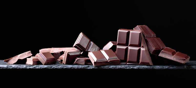 Broken chocolate pieces on a black background.