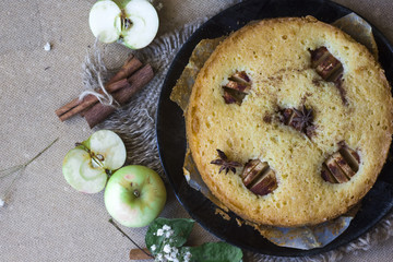 Apple cinnamon cake, cinnamon sticks, apples on the table